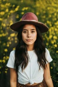 mujer con sombrero y playera blanca