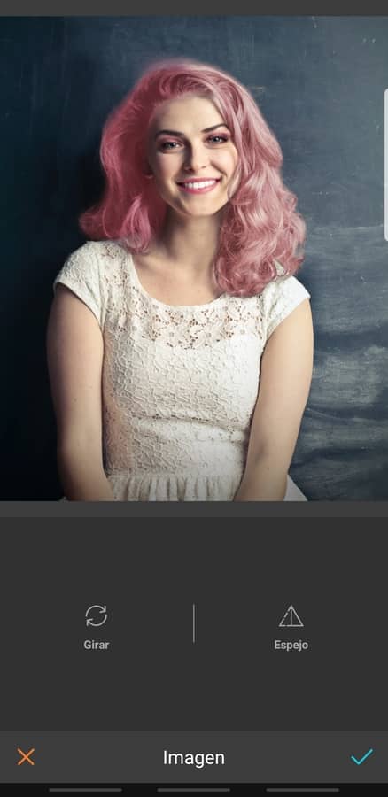 retrato de mujer sonriendo, con maquillaje llamativo y cabello rosa