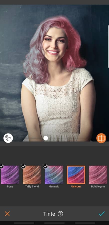 retrato de mujer sonriendo, con maquillaje llamativo y cabello rosa