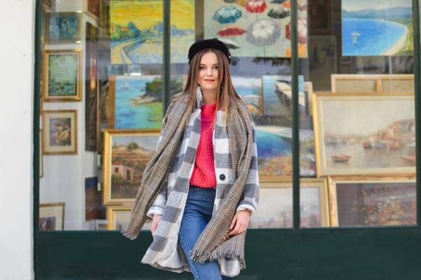 mujer con outfit de invierno frente a una galería de arte