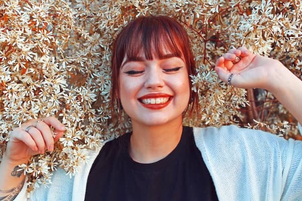 mujer acostada en una cama de flores sonriendo