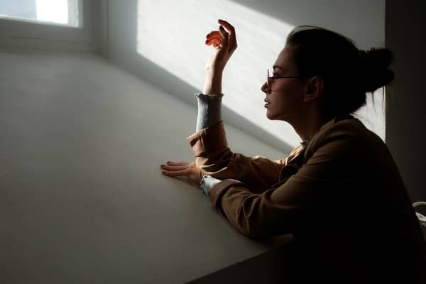 Foto de una mujer mirando por la ventana