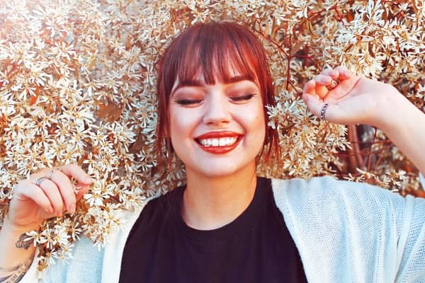 mujer acostada en una cama de flores sonriendo