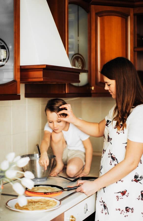 Mamá en la cocina cocinando junto con su hijo varón de 5 años. La foto ha sido editada con AirBrush