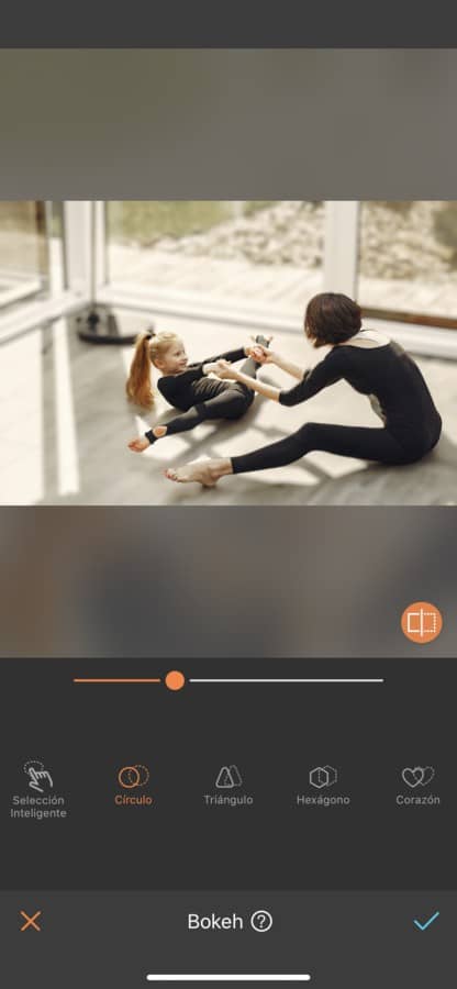 Foto de mamá practicando ballet o gimnasia con su hija. Ambas están vestidas con un payasito negro y están haciendo estiramientos.