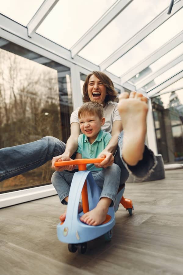 Mamá en un triciclo jugando con su hijo 