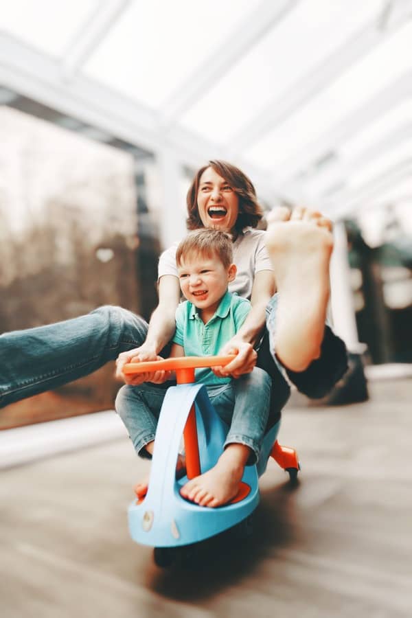 Mamá en un triciclo jugando con su hijo 