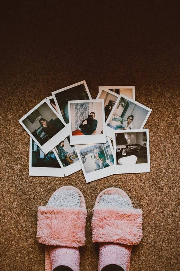 fotografías instantáneas estilo polaroid en el piso junto a unos pies 