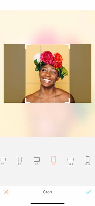 Picture of bald black woman with a crown of flowers being edited by AirBrush with the Crop Tool