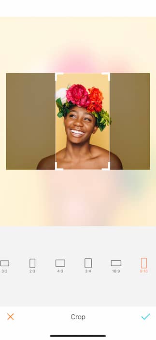 Picture of bald black woman with a crown of flowers being edited by AirBrush with the Crop Tool