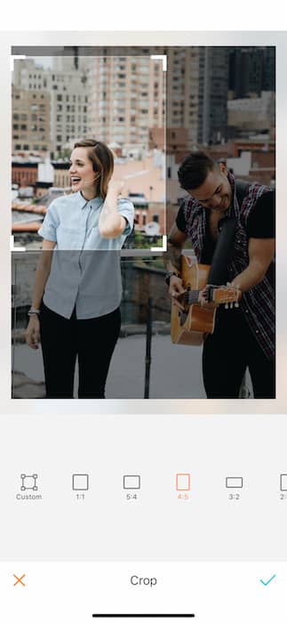 Picture of a woman and man singing and playing in a rooftop being edited by AirBrush with the Crop Tool