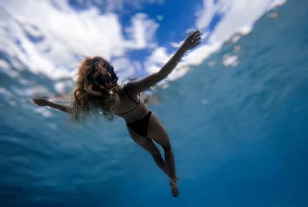 woman in black bikini floating in clear water