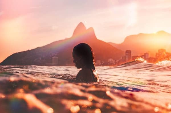 silhouette of a woman in the ocean at sunset