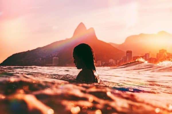 silhouette of a woman in the ocean at sunset