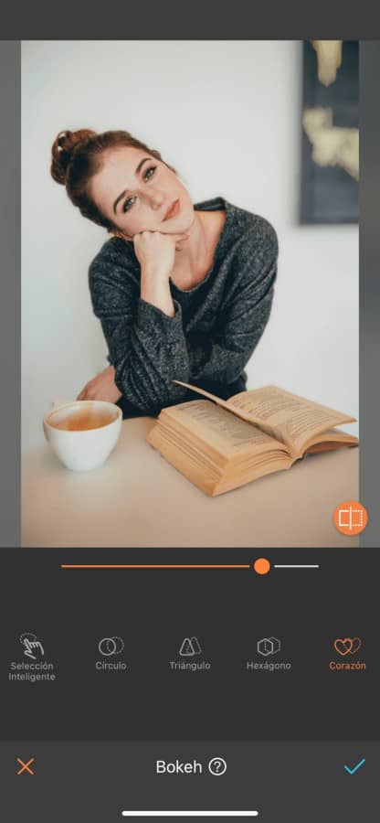 Mujer con un libro abierto sobre la mesa y una taza de café.