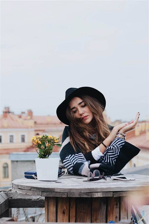 Mujer sentada con paisaje de fondo.