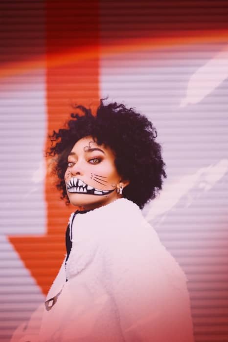 woman in a white jacket wearing Halloween makeup