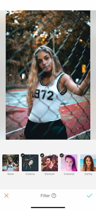 woman in white tank top standing against chainlink fence