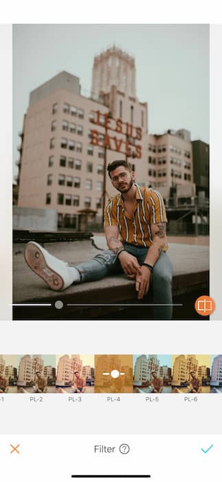 man sitting on rooftop in front of city skyline