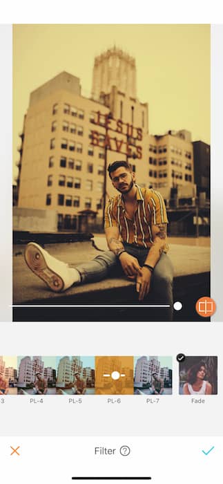 man sitting on rooftop in front of city skyline