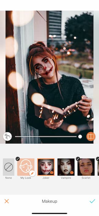 A woman with red hair with a book open being edited by AirBrush with the Joker Makeup