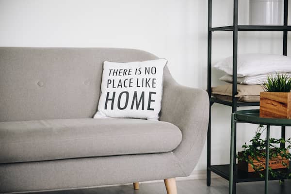 white pillow with black writing on grey couch