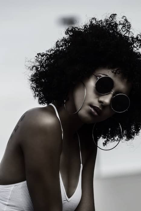 black and white photo of woman in sunglasses and white tank top