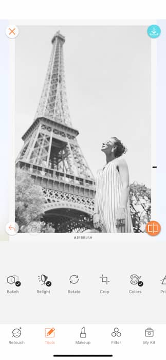 black and white photo of white woman standing in front of the Eiffel Tower