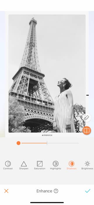 black and white photo of white woman standing in front of the Eiffel Tower