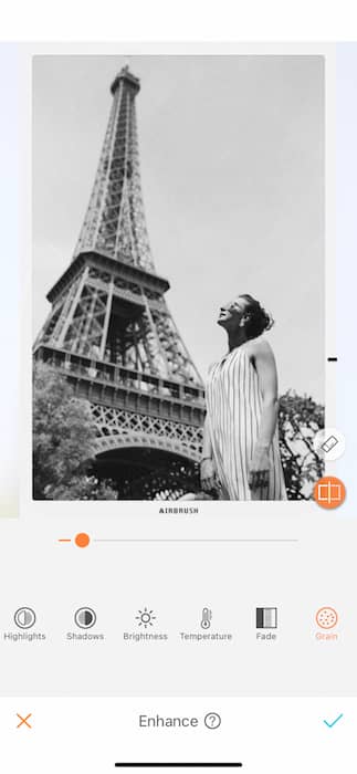 black and white photo of white woman standing in front of the Eiffel Tower