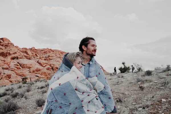 2020 AirBrush edit of couple in desert wrapped in a blanket