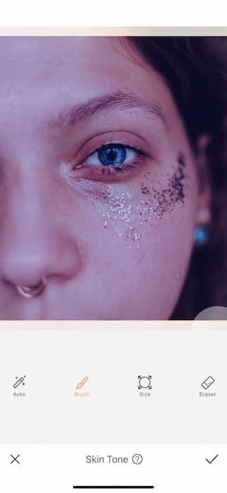 It's an image of a white girl, with blue eyes and glitter in her eyes, being edited with AirBrush App.