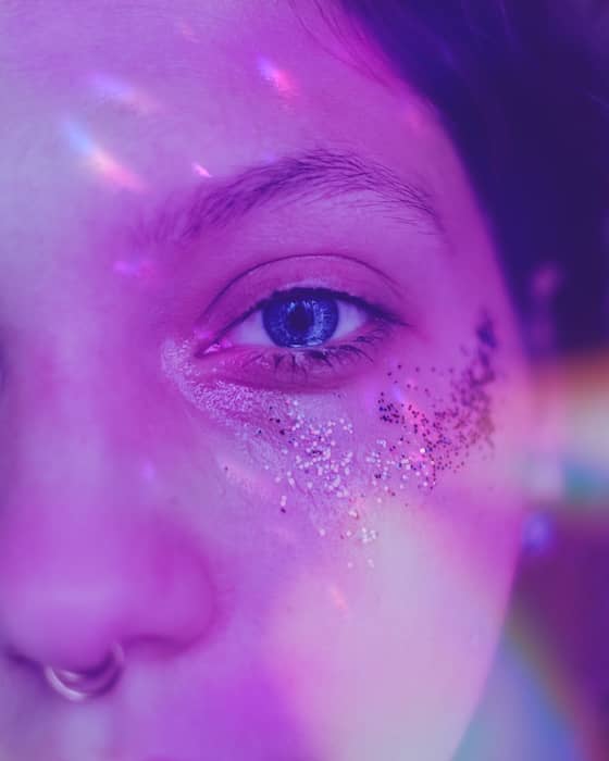 It's an image of a white girl, with blue eyes and glitter in her eyes, being edited with AirBrush App.