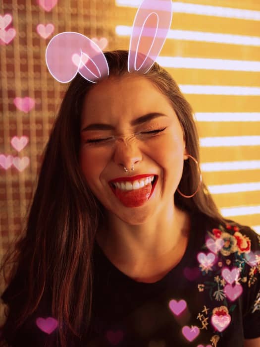 Picture of a brunette with pink bunny ears being edited by AirBrush