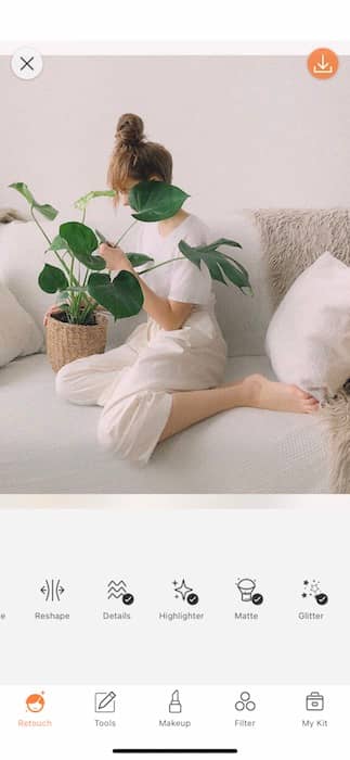 woman sitting on a white couch holding a plant