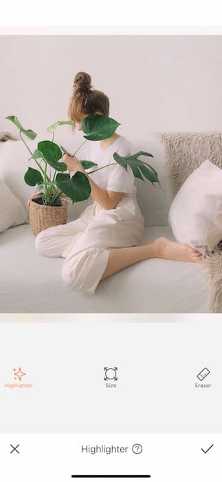 woman sitting on a white couch holding a plant