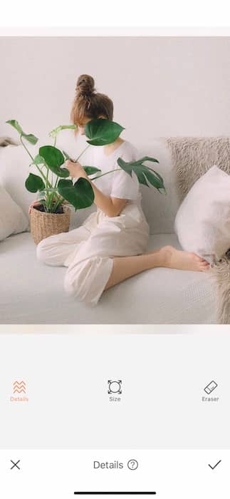 woman sitting on a white couch holding a plant