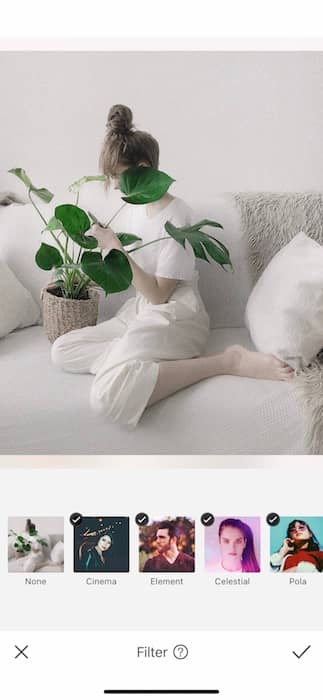 black and white photo of a woman sitting on a white couch holding a plant