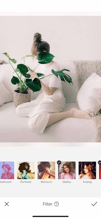 woman sitting on a white couch holding a plant