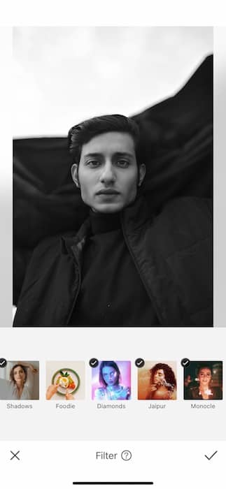 black and white photo of man with dark hair in front of black and white background