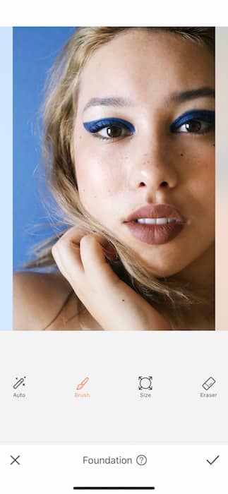 closeup of woman with blonde hair and blue eyeliner in front black background