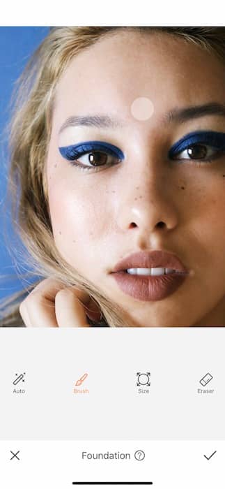 closeup of woman with blonde hair and blue eyeliner in front black background