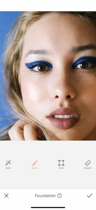 closeup of woman with blonde hair and blue eyeliner in front black background