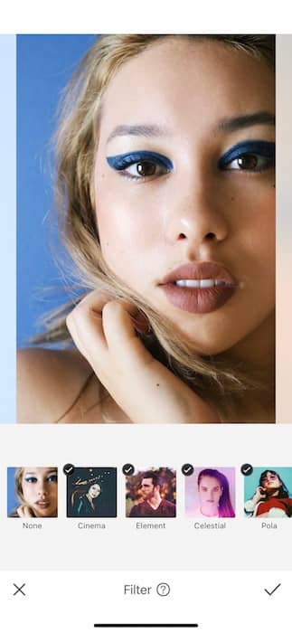 closeup of woman with blonde hair and blue eyeliner in front black background