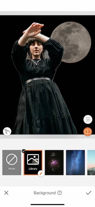 woman wearing a black dress standing in front of the moon