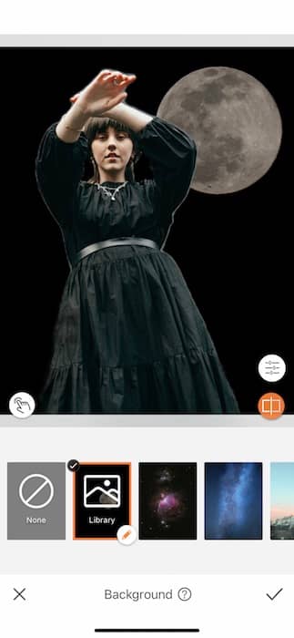 woman wearing a black dress standing in front of the moon