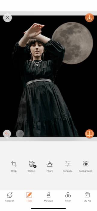 woman wearing a black dress standing in front of the moon