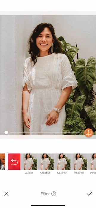  woman in a white dress standing in front of green plants