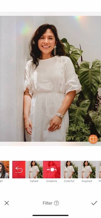  woman in a white dress standing in front of green plants