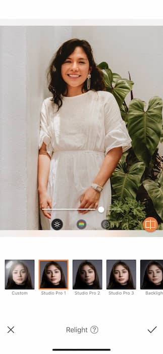  woman in a white dress standing in front of a green plant